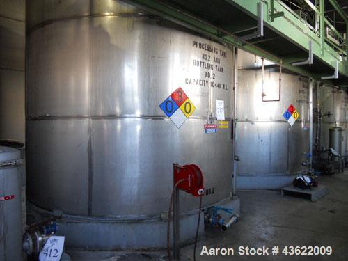 Used Krenz approx. 10,000 gallon stainless steel storage tank. Approx. 12' diameter x 12' straight side. Flat bottom and slight cone top. Various top openings including a 17"manway with cover. 3" Thr...
