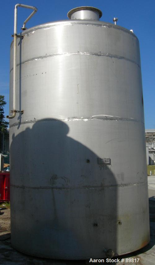 USED: Metal Equipment tank, approximately 6,760 gallon, stainless steel. Approximate 9' diameter x 14' straight side. Misc top openings. 2" end bottom outlet. Flat bottom and dish top.