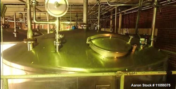 Used Paul Mueller 15,000-gallon stainless steel storage tank with dish top/bottom, 12' diameter, 3 PSI rating, and sanitary construction. Skirt-mounted. Previously used in a brewery. Ideal for food, beverage, and industrial liquid storage.