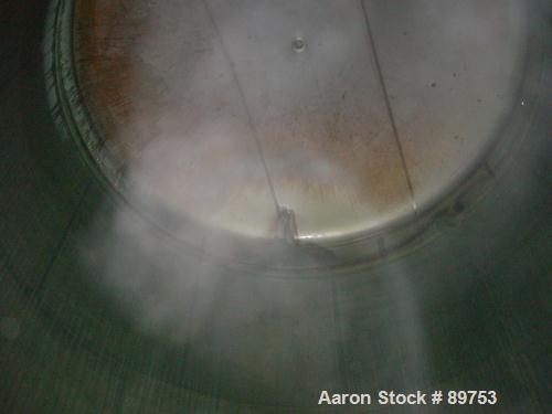 USED: Walker 16,200 gallon, type 304L stainless steel storage tank. Vertical, dished heads. Approximately 12' diameter x 18' straight side. Misc top openings. Side openings include an 18" manway with...