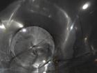 Used 6000 Gallon Stainless Steel Storage Tank. Approximately 94'' diameter, 16' straight wall, side manhole.  Inlets 3-1.5'' threaded 2-3''. Outlets 3'' bolt flange. Tank has large dent in top.