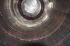 Used Tank, Approximate 19,500 Gallon, 14 Gauge Stainless steel, Vertical. Approximate 130” diameter x 336” straight side, coned top, 7” sloped bottom. Openings top 16” man way with cover and approxim...