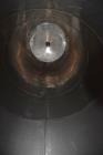Used Tank, Approximate 19,500 Gallon, 14 Gauge Stainless steel, Vertical. Approximate 130” diameter x 336” straight side, coned top, 7” sloped bottom. Openings top 16” man way with cover and approxim...