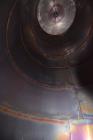 Used Tank, Approximate 19,500 Gallon, 14 Gauge Stainless steel, Vertical. Approximate 130” diameter x 336” straight side, coned top, 7” sloped bottom. Openings top 16” man way with cover and approxim...