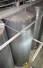 Used Tank, Approximate 19,500 Gallon, 14 Gauge Stainless steel, Vertical. Approximate 130” diameter x 336” straight side, coned top, 7” sloped bottom. Openings top 16” man way no cover and approximat...