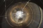 Used Tank, Approximate 19,500 Gallon, 14 Gauge Stainless steel, Vertical. Approximate 130” diameter x 336” straight side, coned top, 7” sloped bottom. Openings top 16” man way with cover and approxim...