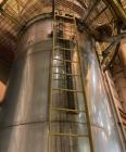 Used Approximate 6,750 gallon Stainless Steel Tank With Diaphragm Pump, V-4332. Flat top with misc. inlets & openings. Cone bottom with center bottom outlet. Side bottom manway. Has stainless steel l...