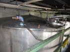 Used Krenz approx. 10,000 gallon stainless steel storage tank. Approx. 12' diameter x 12' straight side. Flat bottom and slight cone top. Various top openings including a 17